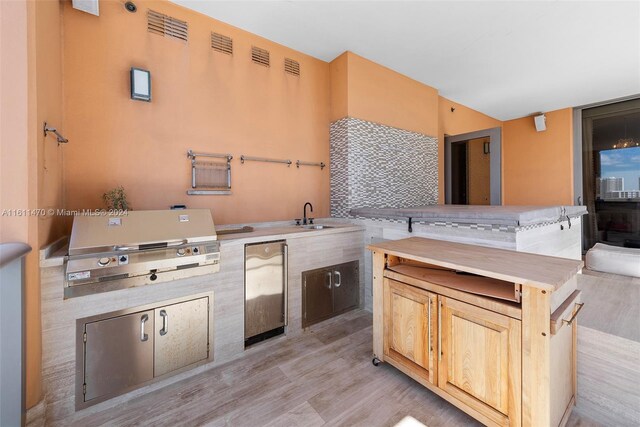 kitchen featuring light hardwood / wood-style floors, sink, refrigerator, and light brown cabinets