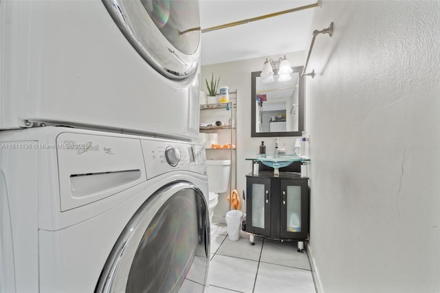 laundry area with light tile patterned floors and stacked washer and dryer