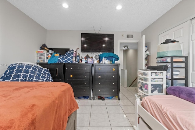 tiled bedroom with a textured ceiling