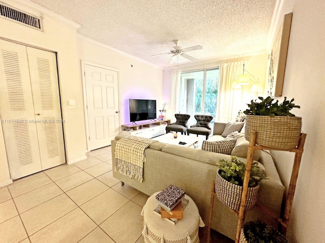 tiled living room featuring ceiling fan, crown molding, and a textured ceiling