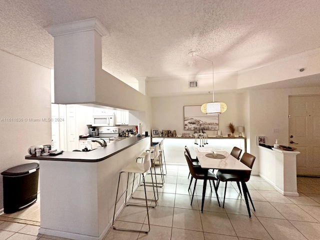 kitchen with stainless steel electric range oven, kitchen peninsula, a breakfast bar area, and light tile patterned floors