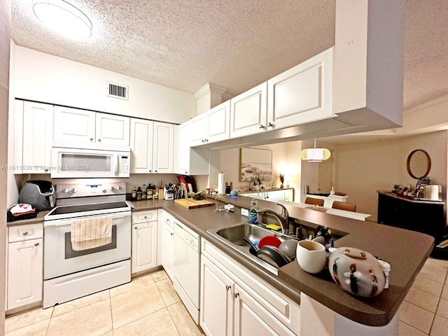 kitchen featuring kitchen peninsula, white appliances, sink, light tile patterned floors, and white cabinetry