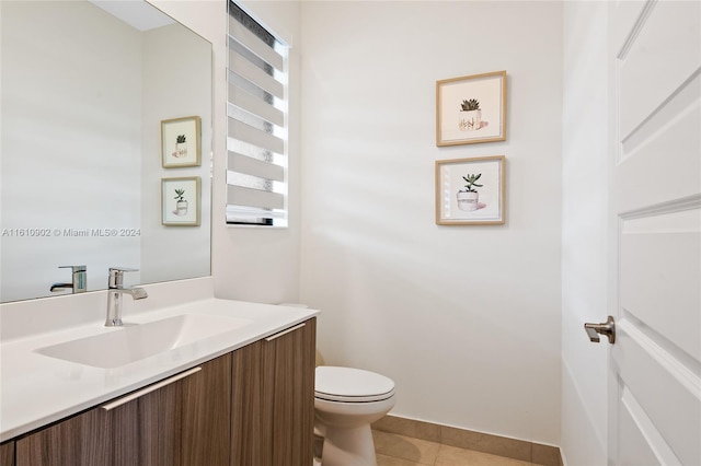 bathroom featuring tile floors, vanity, and toilet