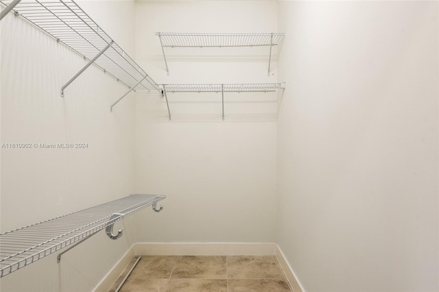 walk in closet with tile flooring