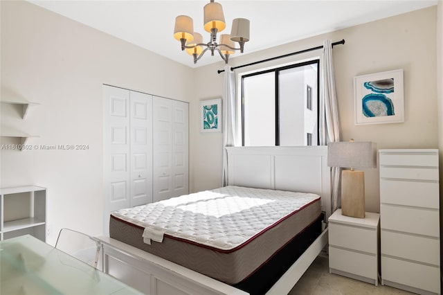 tiled bedroom with a closet and an inviting chandelier