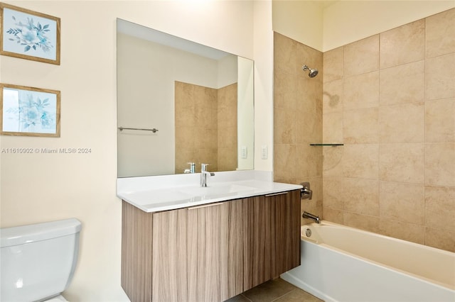 full bathroom with tile flooring, tiled shower / bath combo, vanity, and toilet