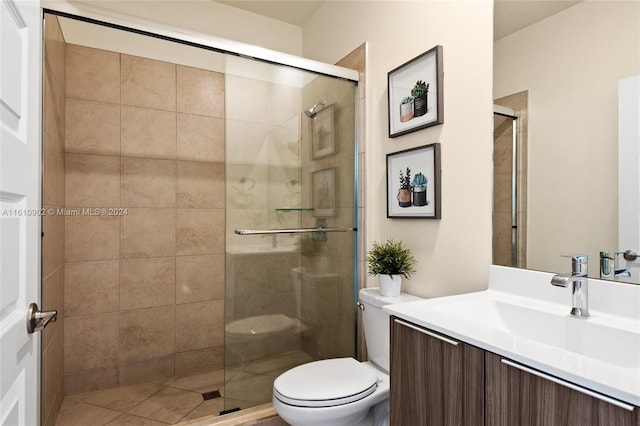 bathroom with a shower with shower door, vanity, and toilet