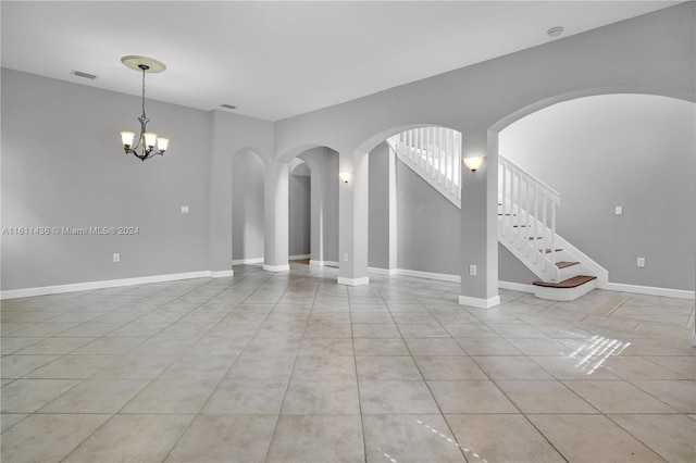 unfurnished living room featuring a notable chandelier and light tile patterned flooring