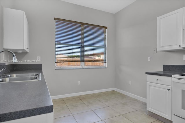 kitchen featuring range, light tile patterned floors, white cabinetry, and sink