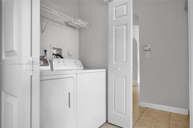 laundry area featuring light tile patterned flooring and washing machine and clothes dryer