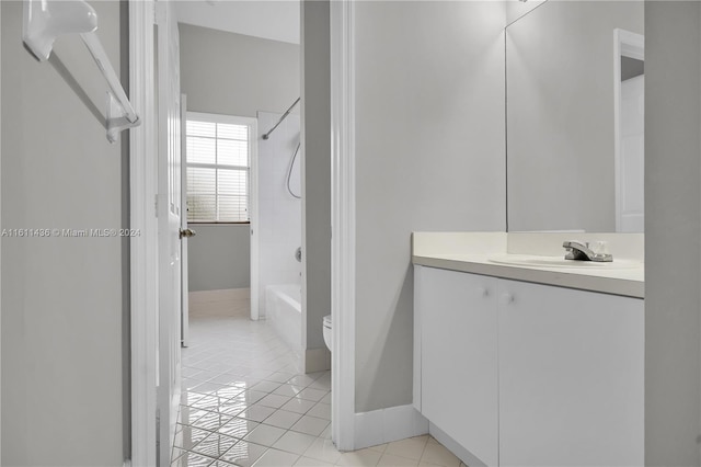 full bathroom with tile patterned flooring, vanity, tiled shower / bath combo, and toilet