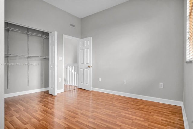 unfurnished bedroom with light hardwood / wood-style flooring and a closet