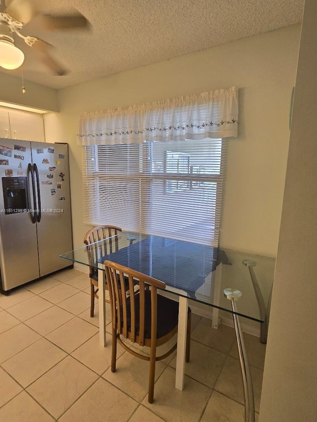 dining room with ceiling fan, tile patterned flooring, and a textured ceiling