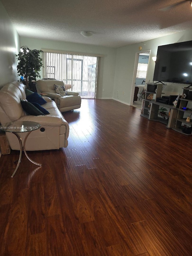 living room featuring dark hardwood / wood-style floors and a textured ceiling