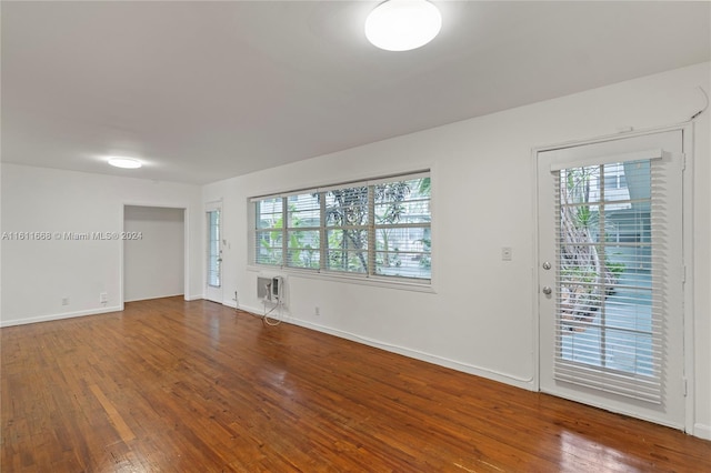 empty room featuring hardwood / wood-style floors and a wall mounted air conditioner