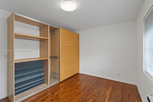 unfurnished bedroom featuring a closet and hardwood / wood-style floors