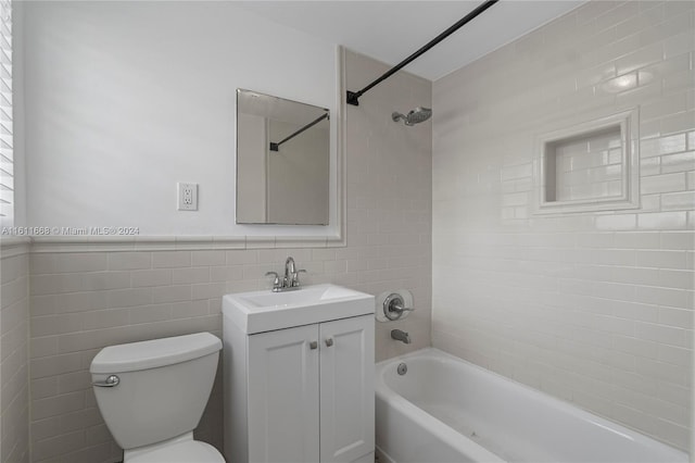 full bathroom featuring decorative backsplash, tiled shower / bath combo, vanity, tile walls, and toilet