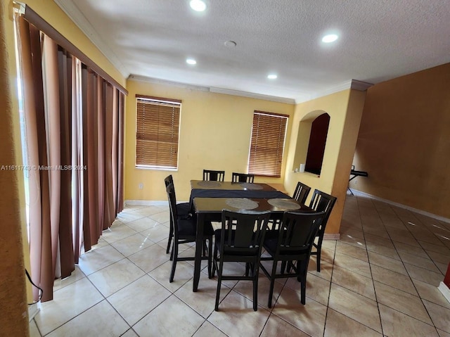 dining room featuring light tile patterned floors, baseboards, crown molding, a textured ceiling, and recessed lighting