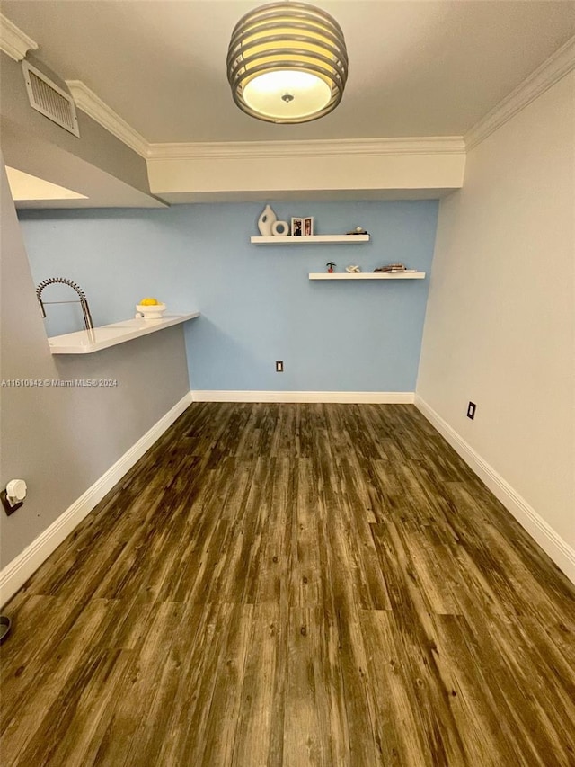 laundry room featuring dark hardwood / wood-style flooring and crown molding