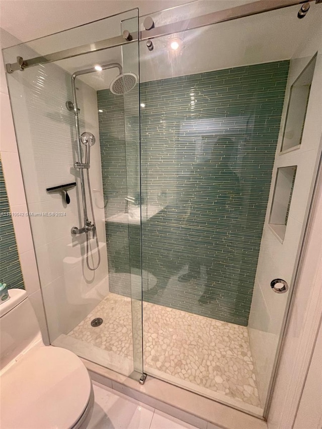 bathroom with tile patterned floors, toilet, and walk in shower