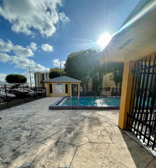 view of swimming pool featuring an outbuilding and a patio