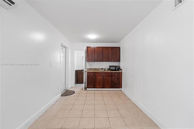 kitchen featuring dark brown cabinetry and light tile flooring