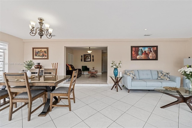 tiled dining room with a chandelier