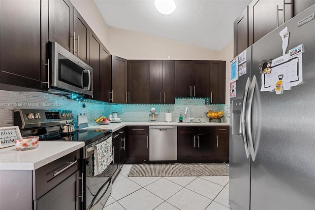 kitchen with light tile flooring, stainless steel appliances, backsplash, sink, and lofted ceiling