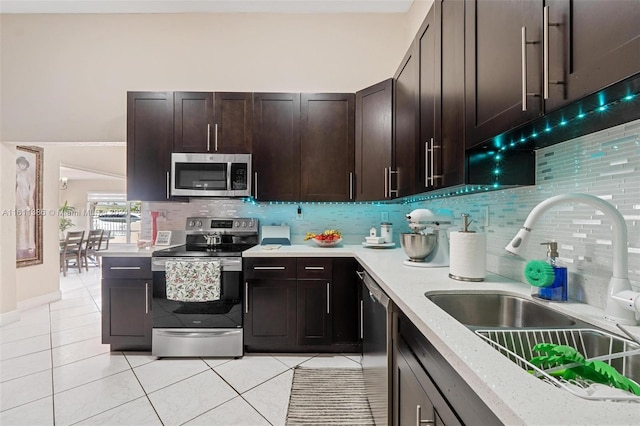 kitchen with appliances with stainless steel finishes, sink, backsplash, and dark brown cabinets