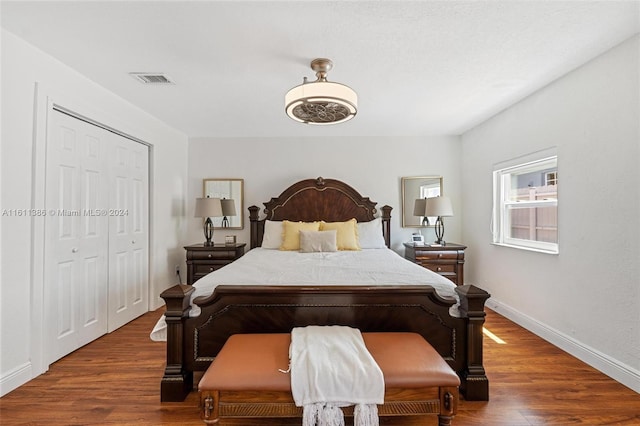 bedroom with dark hardwood / wood-style floors and a closet