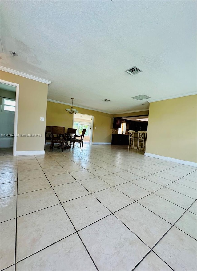 interior space with ornamental molding, light tile patterned flooring, and a textured ceiling