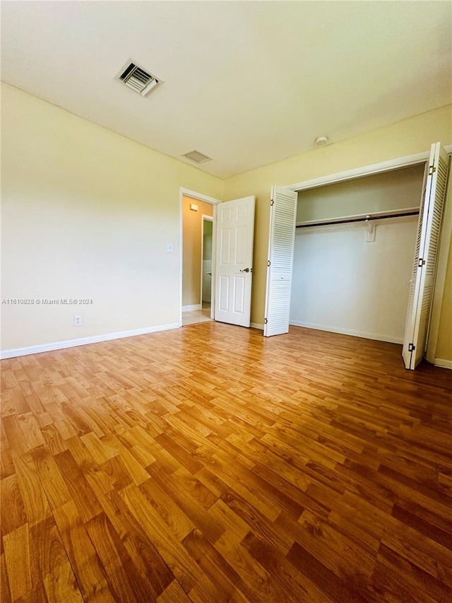 unfurnished bedroom with a closet and wood-type flooring