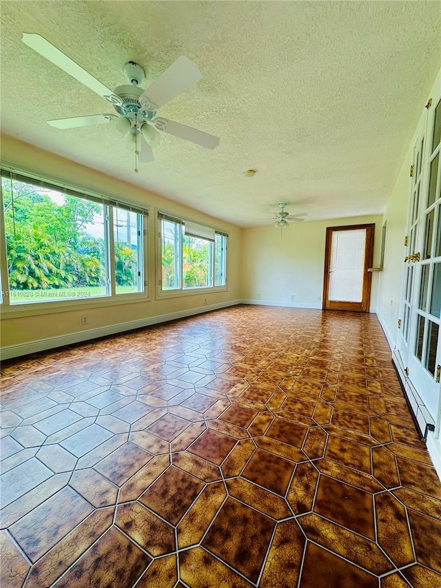 unfurnished room with french doors, a textured ceiling, and ceiling fan