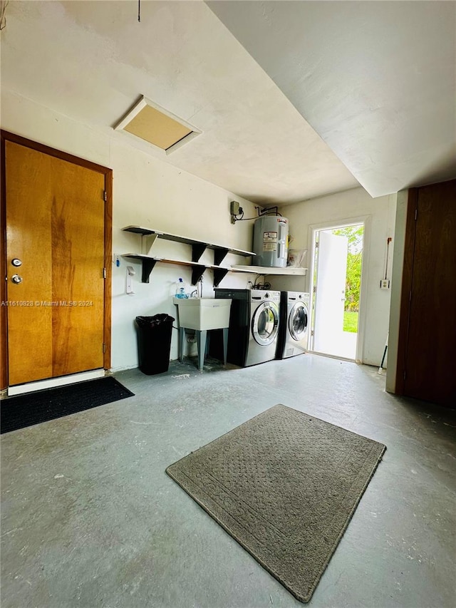 clothes washing area featuring water heater, sink, and washing machine and clothes dryer