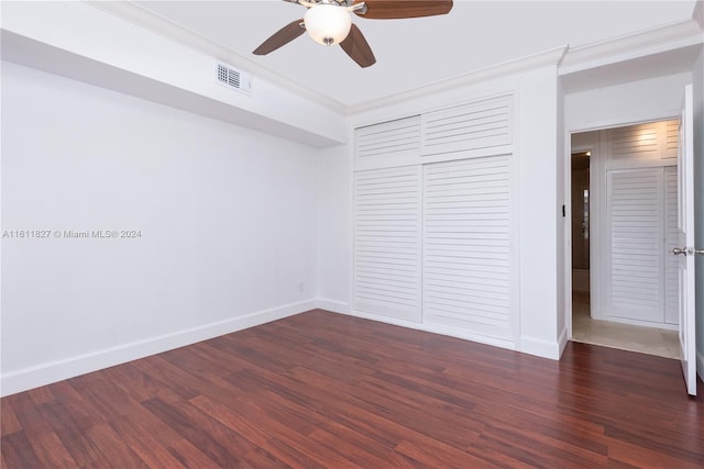 unfurnished bedroom with dark hardwood / wood-style flooring, a closet, ornamental molding, and ceiling fan