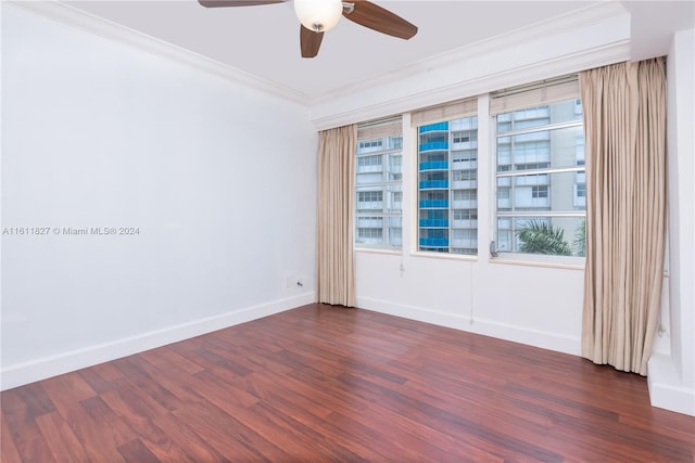 empty room with dark wood-type flooring, a healthy amount of sunlight, and crown molding