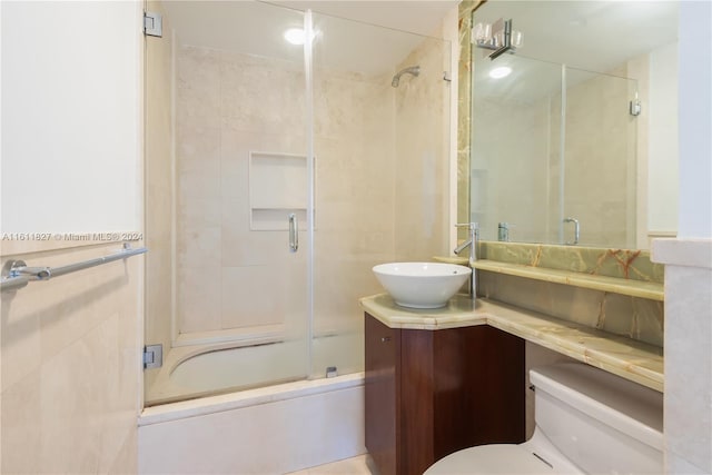 full bathroom with bath / shower combo with glass door, vanity, and toilet