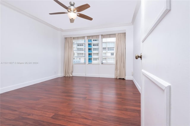 empty room featuring dark hardwood / wood-style floors, crown molding, and ceiling fan