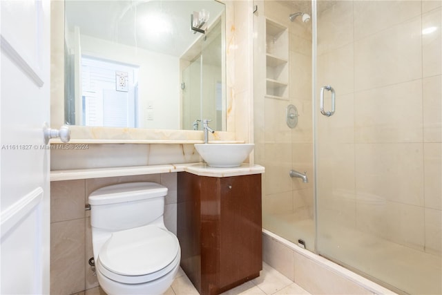 bathroom with vanity, tile patterned flooring, toilet, and an enclosed shower