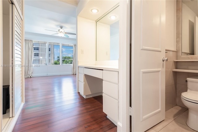 bathroom with wood-type flooring, ceiling fan, toilet, and vanity