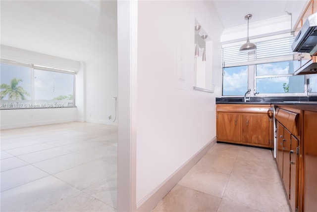 kitchen with extractor fan, sink, pendant lighting, and light tile patterned floors