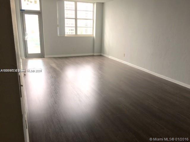 unfurnished room with a wealth of natural light and dark hardwood / wood-style floors