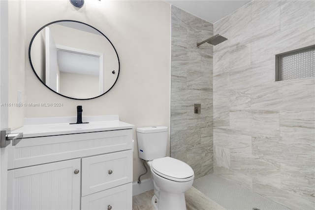 bathroom featuring vanity, toilet, and tiled shower