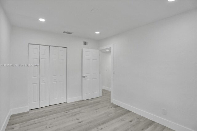 unfurnished bedroom with light hardwood / wood-style floors and a closet