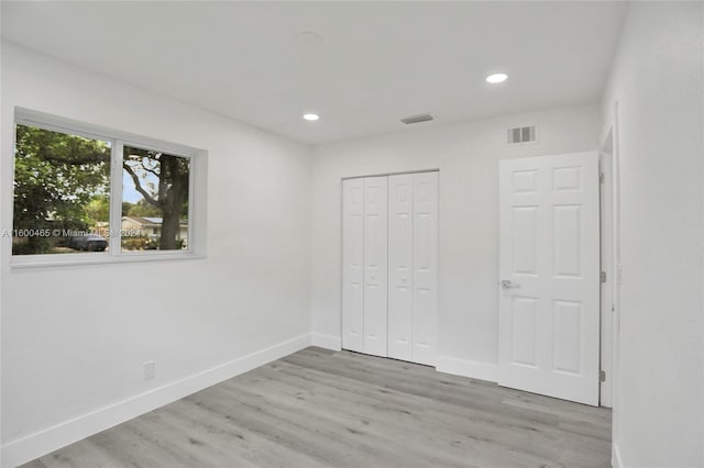 unfurnished bedroom featuring light hardwood / wood-style floors and a closet