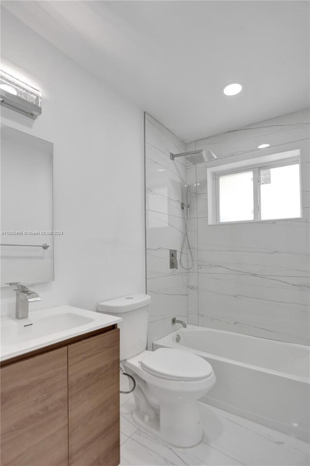 full bathroom featuring tile patterned flooring, toilet, vanity, and tiled shower / bath