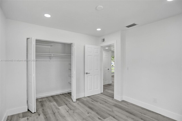 unfurnished bedroom with a closet and light wood-type flooring