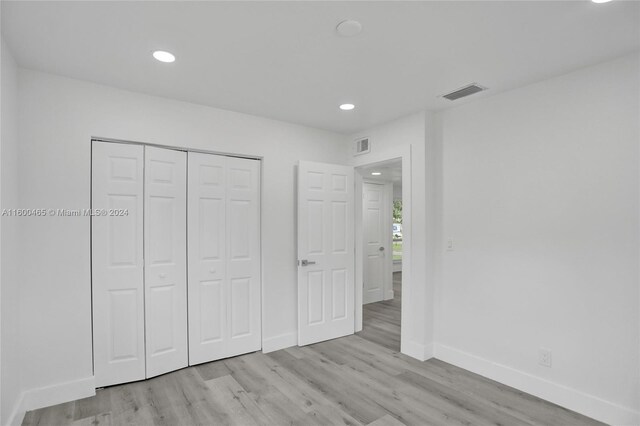 unfurnished bedroom featuring light hardwood / wood-style flooring and a closet