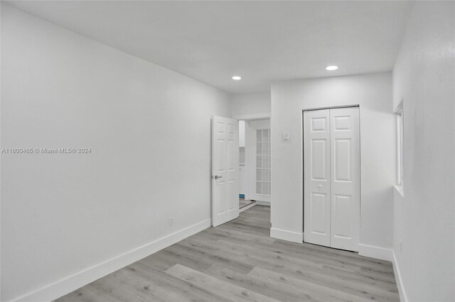 unfurnished bedroom featuring a closet and light wood-type flooring