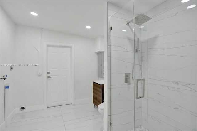 bathroom with tile patterned floors, a shower with door, toilet, and vanity